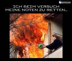 Ein Mann steht an einem Fenster, hinter ihm lodert ein großes Feuer. Der Text auf dem Bild lautet: "ICH BEIM VERSUCH MEINE NOTEN ZU RETTEN..."