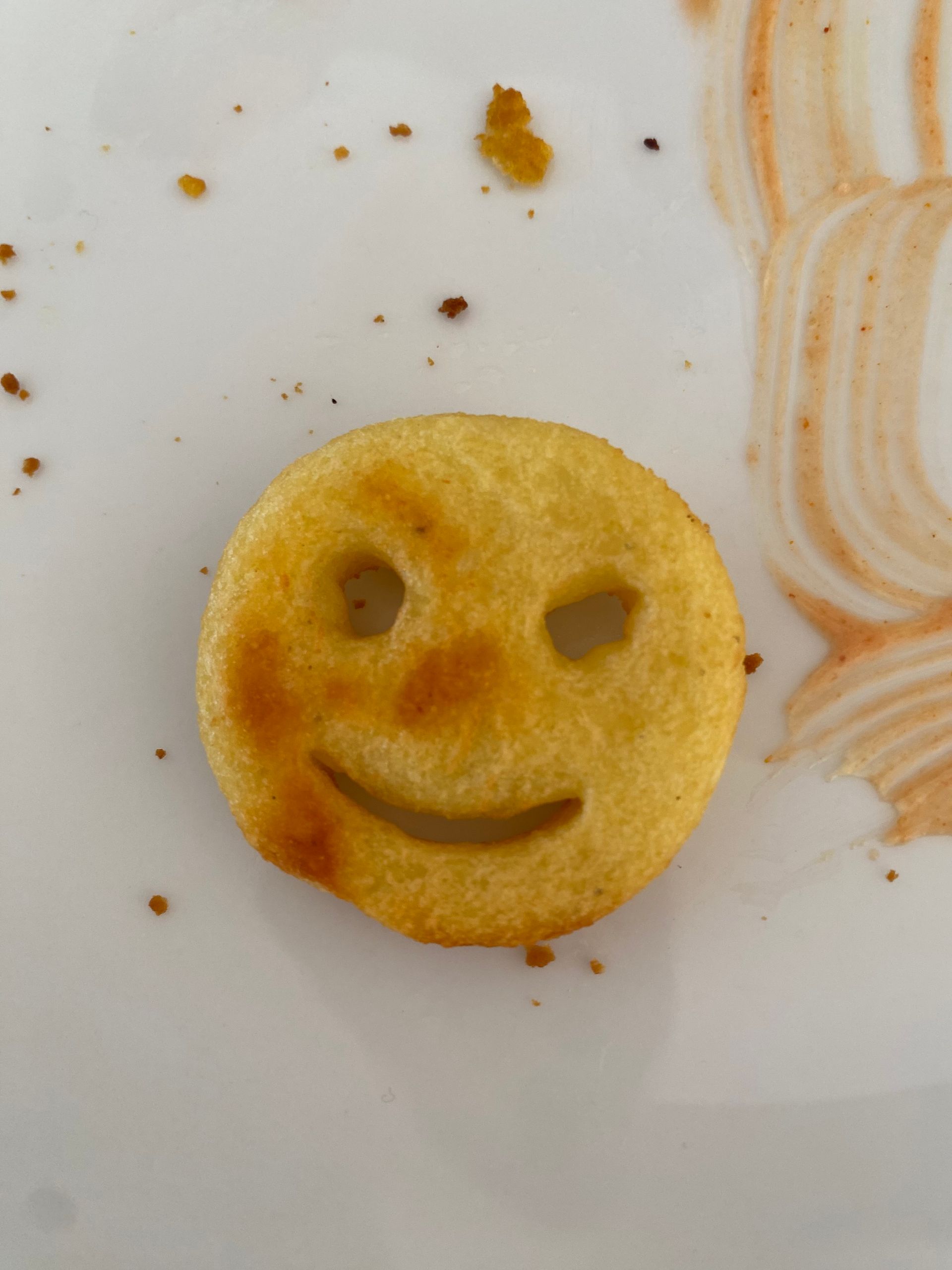 Ein Smiley-Gesicht aus Kartoffel auf einem Teller.