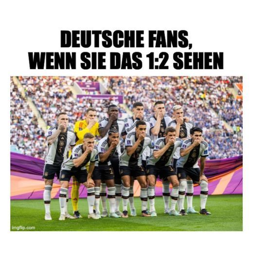 Ein Foto von der deutschen Fußballnationalmannschaft, alle mit der Hand vor dem Mund, vor einer Menge.