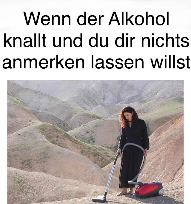 Eine Frau in einem schwarzen Kleid staubsaugt in einer Wüstenlandschaft. Der Text über dem Bild lautet: "Wenn der Alkohol knallt und du dir nichts anmerken lassen willst."