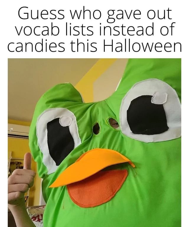 Eine Person trägt ein grünes Duolingo-Eulen-Kostüm mit gelbem Schnabel. Der Text im Bild lautet: "Guess who gave out vocab lists instead of candies this Halloween."