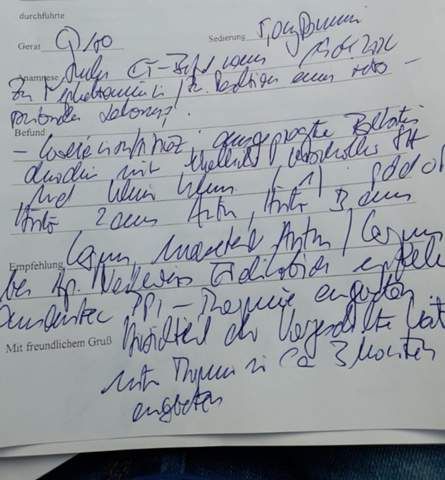 Das Bild zeigt einen handschriftlichen medizinischen Bericht auf einem Formular. Die Schrift ist schwer lesbar und die Tinte ist blau. Der Text ist voller medizinischer Fachbegriffe. Es ist sehr schwer, die Wörter richtig zu entziffern.