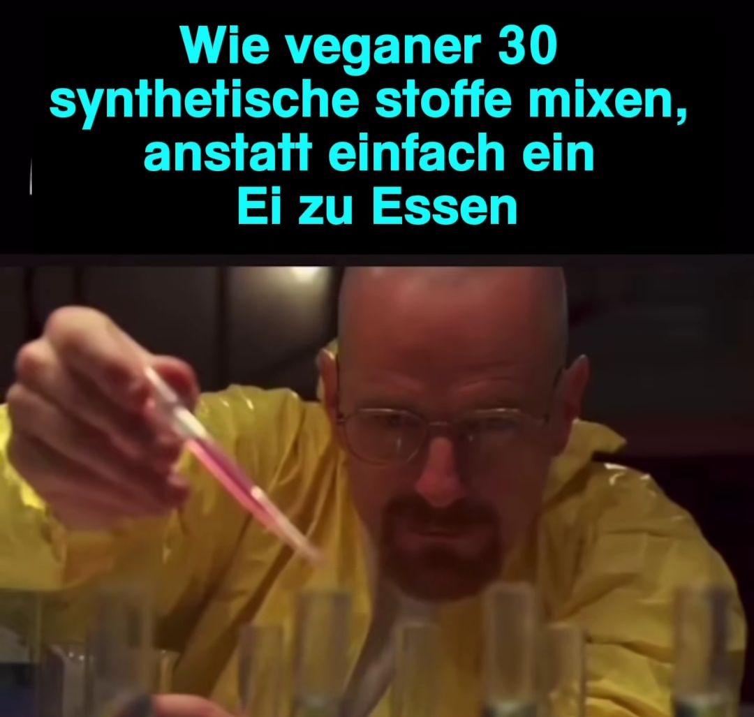 Ein Mann mit einer gelben Schutzkleidung und Brille hält ein Reagenzglas mit einer rosafarbenen Flüssigkeit. Im Hintergrund sind weitere Reagenzgläser zu sehen. Über dem Bild steht in blauer Schrift: "Wie Veganer 30 synthetische Stoffe mixen, anstatt einfach ein Ei zu Essen."